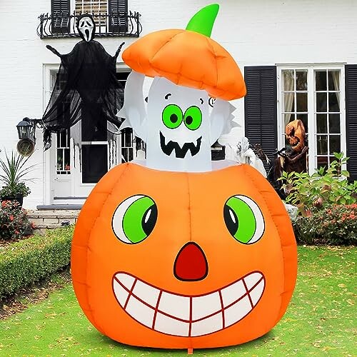 Inflatable Halloween ghost inside a large pumpkin decoration in front of a house.