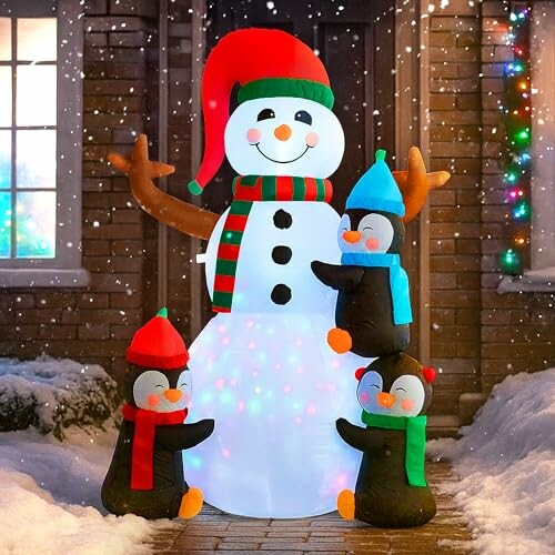 Inflatable snowman with penguins in winter scene.